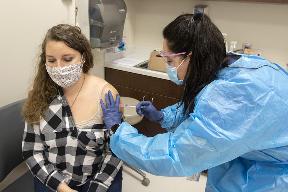 COVID-19 trial participant Kelly Warren gets a shot of what could be the AstraZenaca vaccine.