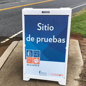 closeup of a sandwich board sign for a COVID testing site in Spanish