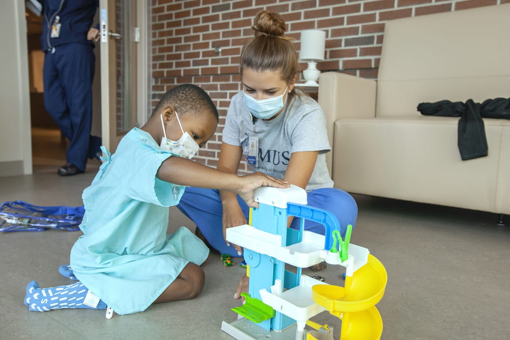 K.J. Griffin plays with nurse Amber Ryan the day after receiving his first infusion of remestemcel-L.