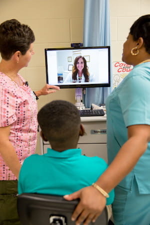  Connecting Kids to Care: Lynn Floyd  and Tina Brown collaborate with nurse practitioner Kelli Garber through telehealth to care for a student at Hemingway Elementary School.