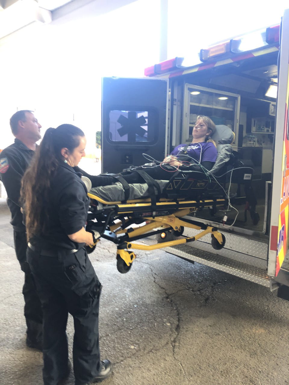 A girl is loaded into the back of an ambulance