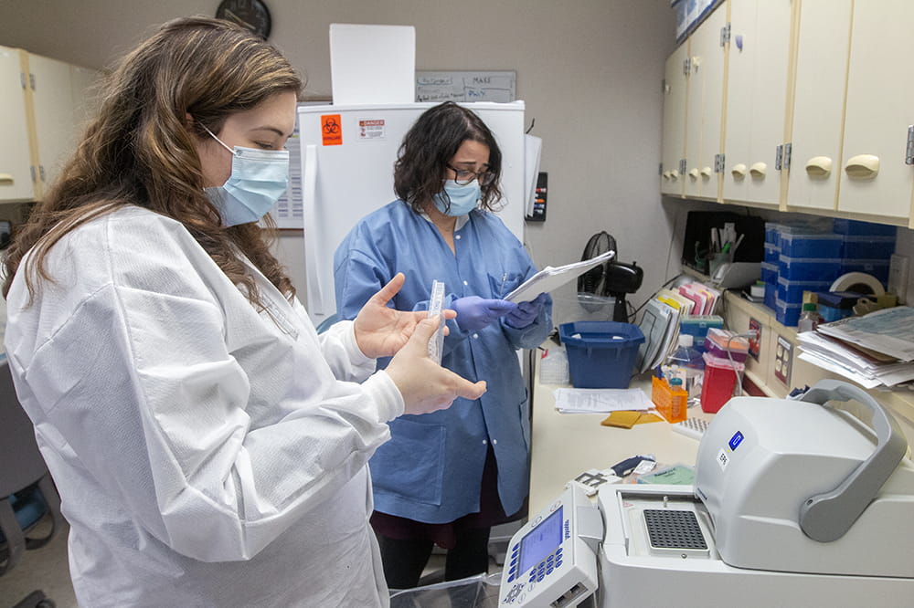 Dr. Julie Hirschhorn talks with Kristen Maurer, a medical technologist who is indexing each coronavirus-positive sample so 384 samples can be sequenced at the same time.