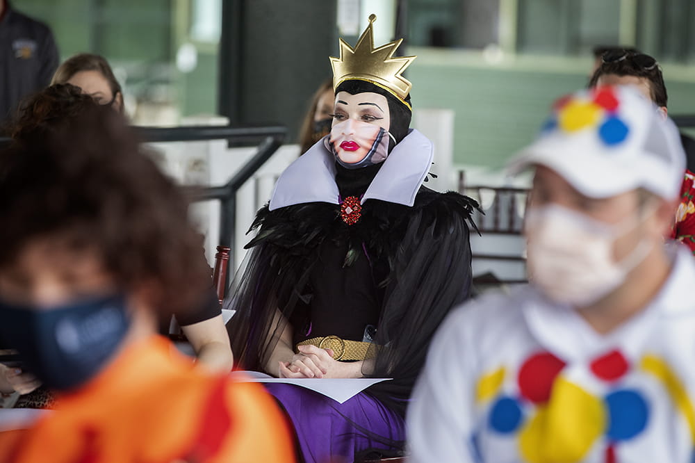 an imperious Disney Evil Queen sits in the audience