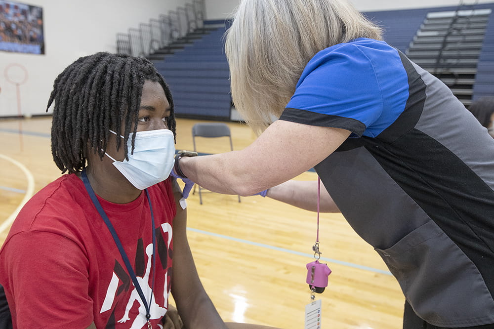 Dorien Jenkins-Hall gets a COVID-19 vaccine at Stall High School.