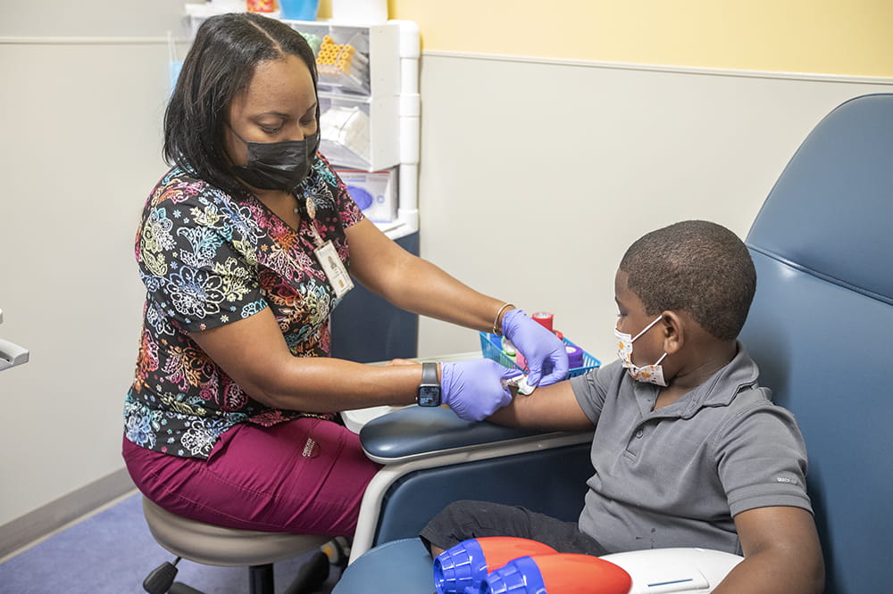MUSC pediatric phlebotomist Kqiana Young draws Nolan Rivers' blood in a COVID-19 vaccine trial.