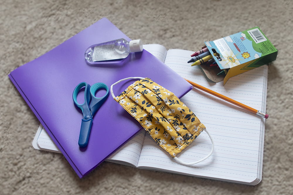 Folder, notebook, scissors, hand sanitizer and a child size mask.