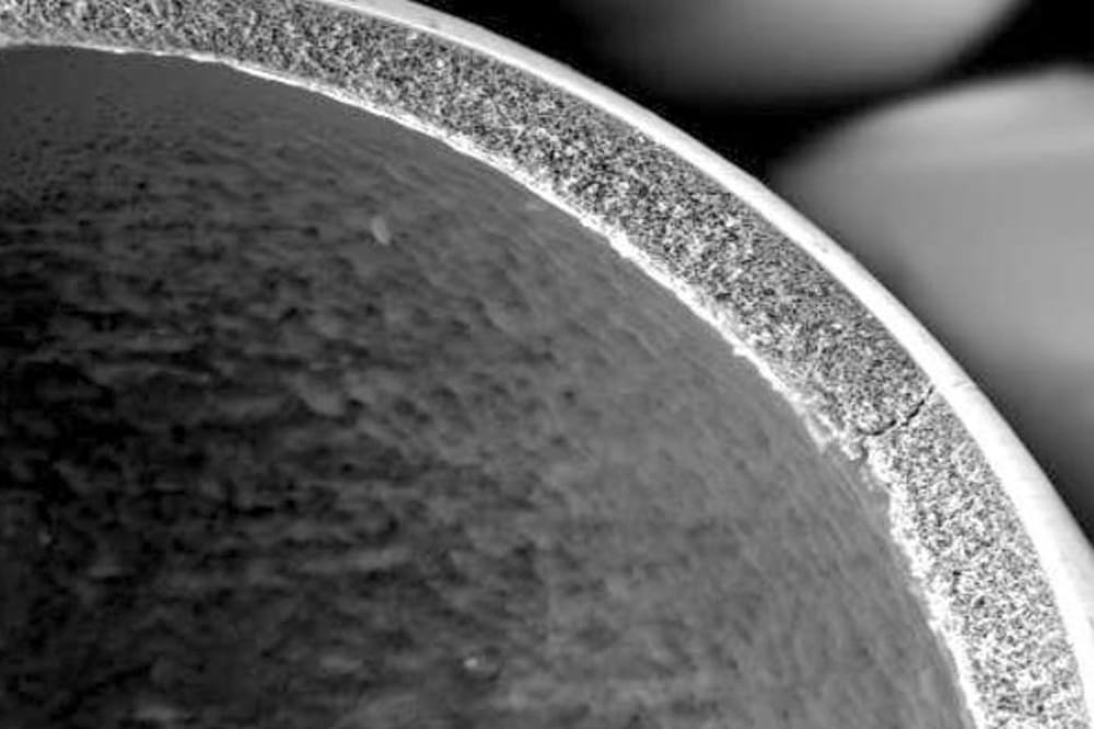 L'enveloppe extérieure d'une microsphère de verre creuse à paroi poreuse.  Photographie fournie par le Dr William D. Hill. 