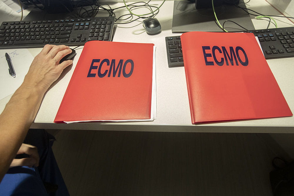 Two red folders with the word ECMO on them.