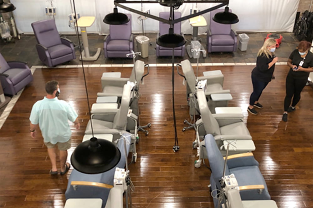 an overhead shot of an open room with rows of large chairs similar to a blood donation center