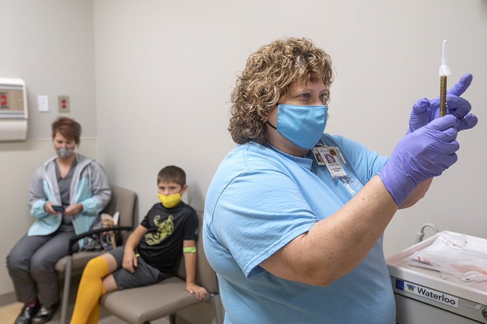 Nurse Karen Hawkins prepares the Moderna vaccine in a clinical trial for kids.