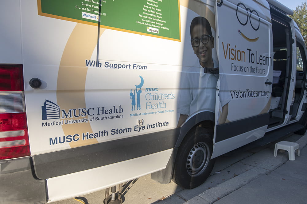 A van is adorned with graphics advertising the nonprofit group Vision to Learn and the support provided by MUSC Health, MUSC Children's Health and the MUSC Storm Eye Institute