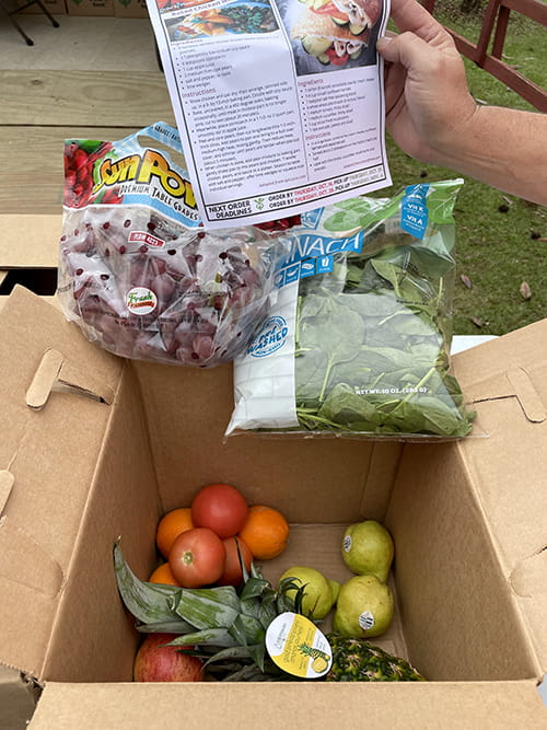 an open cardboard box with various veggies inside