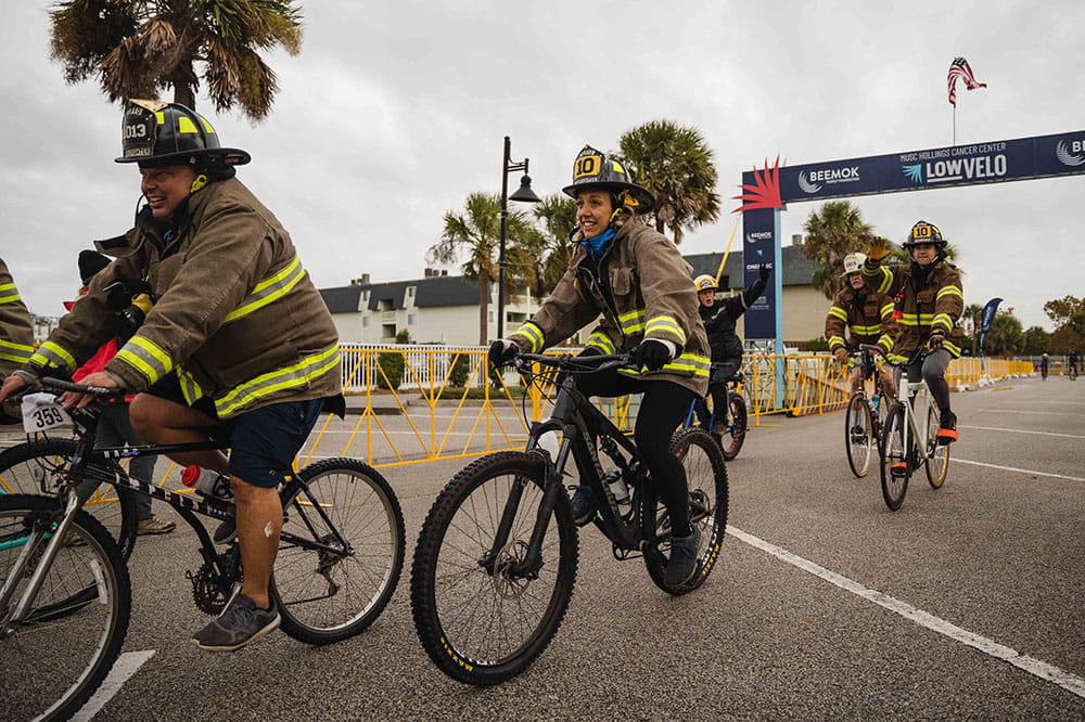 Group of Isle of Palms firefighters ride their bikes in Lowvelo21 wearing their fire gear