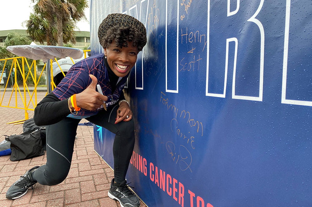 Ja'Net Bishop gives a thumbs up after writing a message on the Why I Ride wall at Lowvelo21