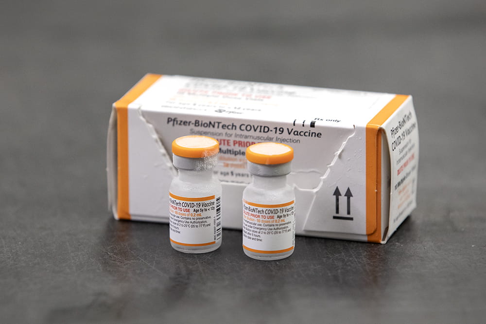 closeup image of two vials and a box of the Pfizer pediatric covid vaccine