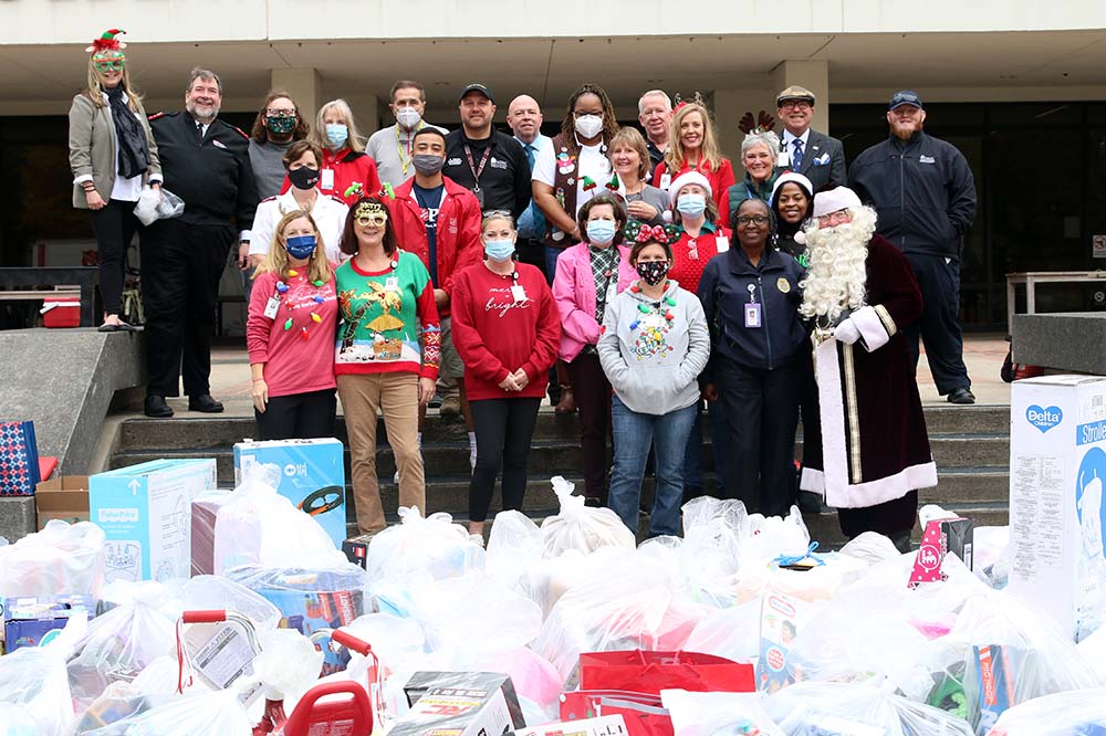 Volunteers and employees from MUSC and the Salvation Army gather behind bags of donated gifts.