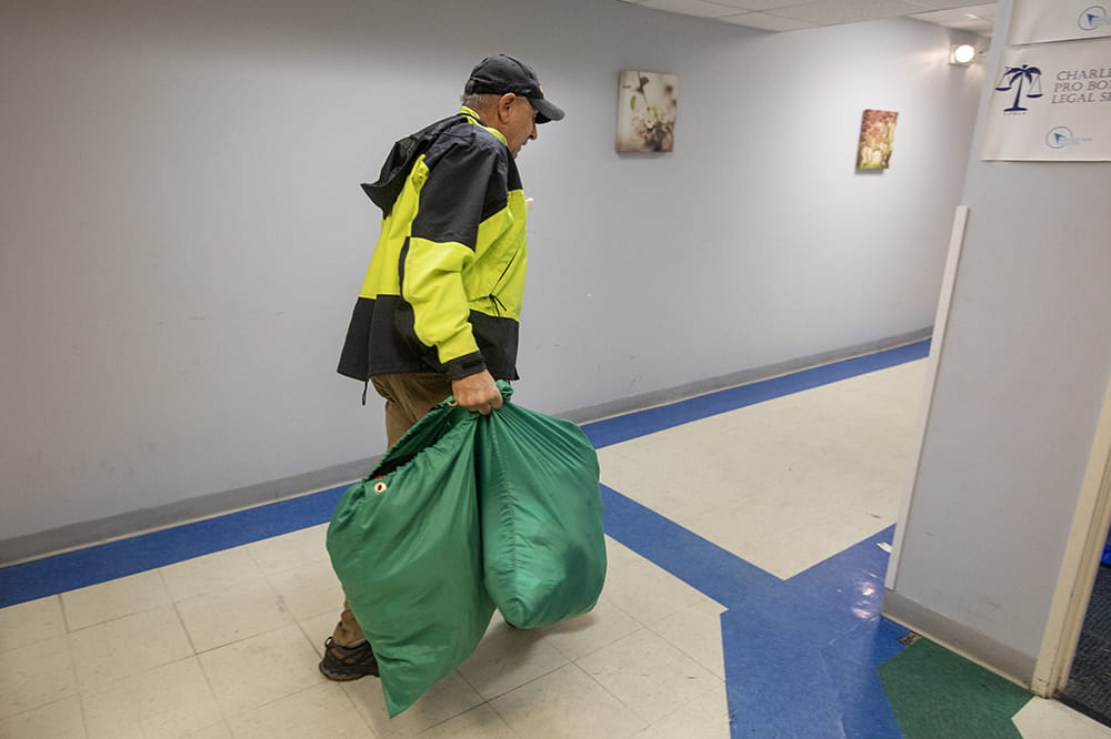Allan Woods of the Charleston Street Wellness Patrol carries bags of supplies in the Navigation Center.