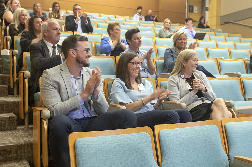 Franco Cardillo, Dianna Pelay y Diane Story aplauden en Shark Tank 2022.  Están sentados en el auditorio.