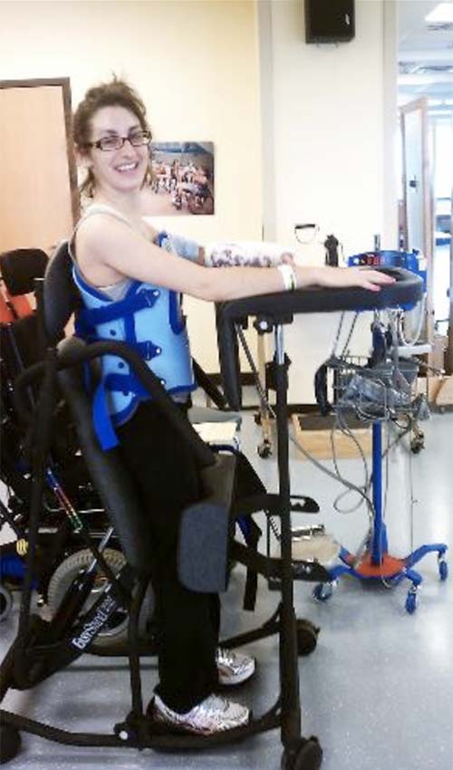 Julia Rodes during her rehabilitation at the Shepherd Center. She is smiling while appearing to exercise on special equipment.
