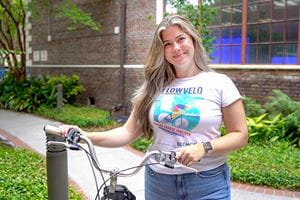 photo of a young woman in tee shirt and jeans posing with bike