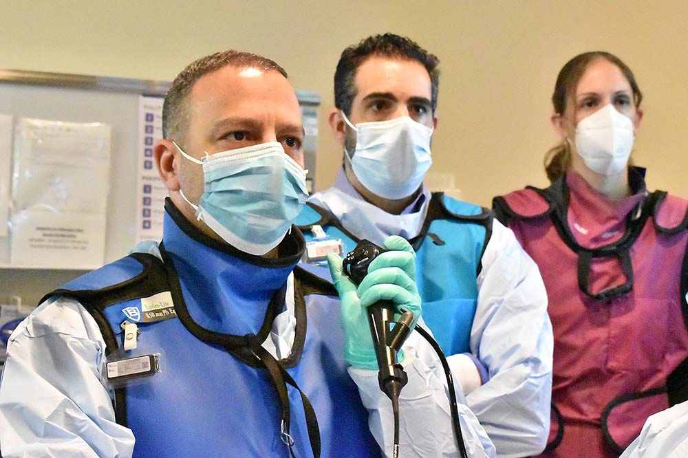 Two men and a woman wearing masks look to the side. They are Ramzy Hourany, M.D., Rami Zebian, M.D. and Katlyn Baxter, DO.