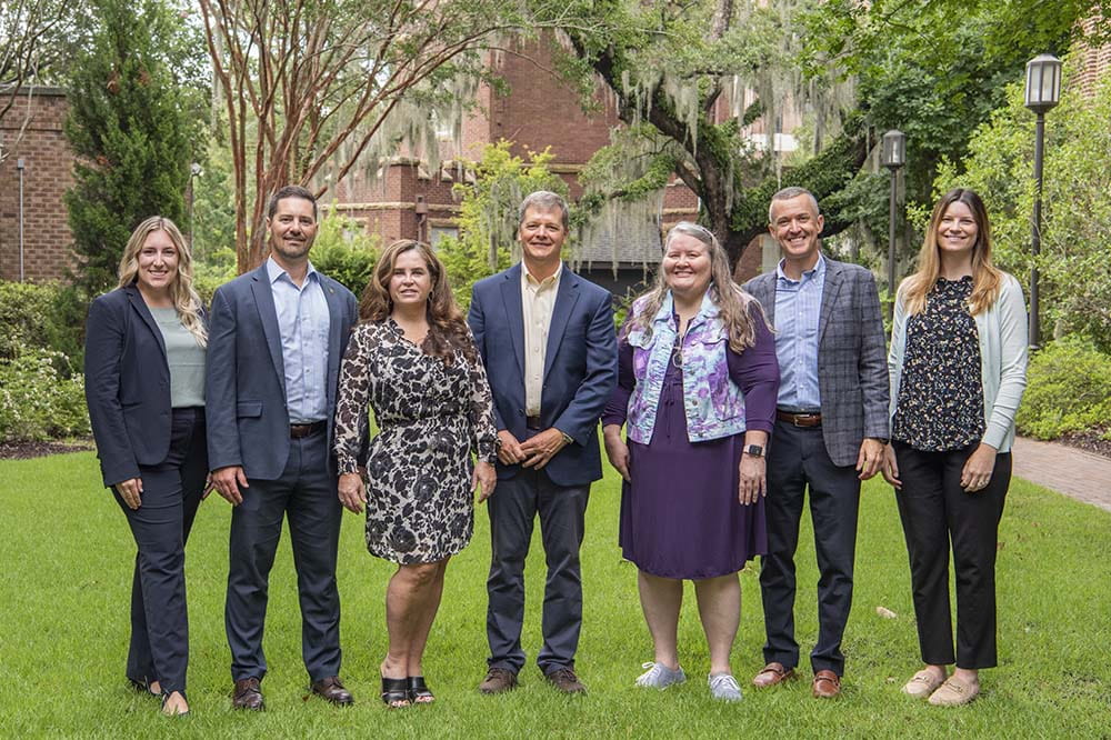 Staff of the Zucker Institute for Innovation Commercialization stand outside smiling. Kaitlyn Crobar, Troy Huth, Alia Akins, Michael Yost, Pamela Kaufman, Paul Asper, Casey Charboneau.