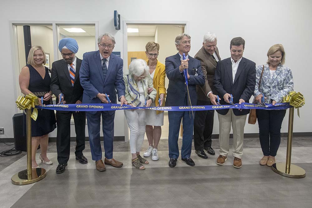 Charleston Mayor John Tecklenburg looks up as he and other leaders cut a ribbon to mark the opening of a dental clinic in West Ashley.