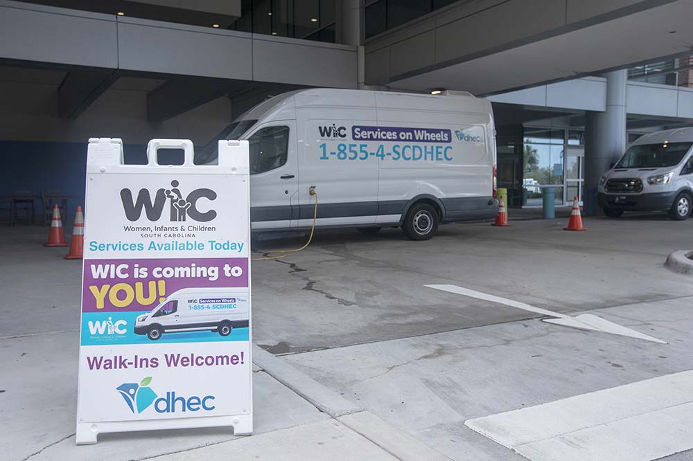WIC sign and WIC van in the parking lot.
