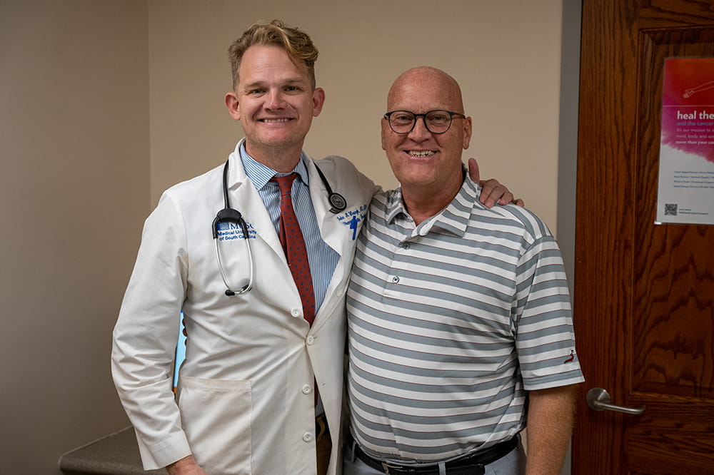 a smiling lung cancer patient with his oncologist