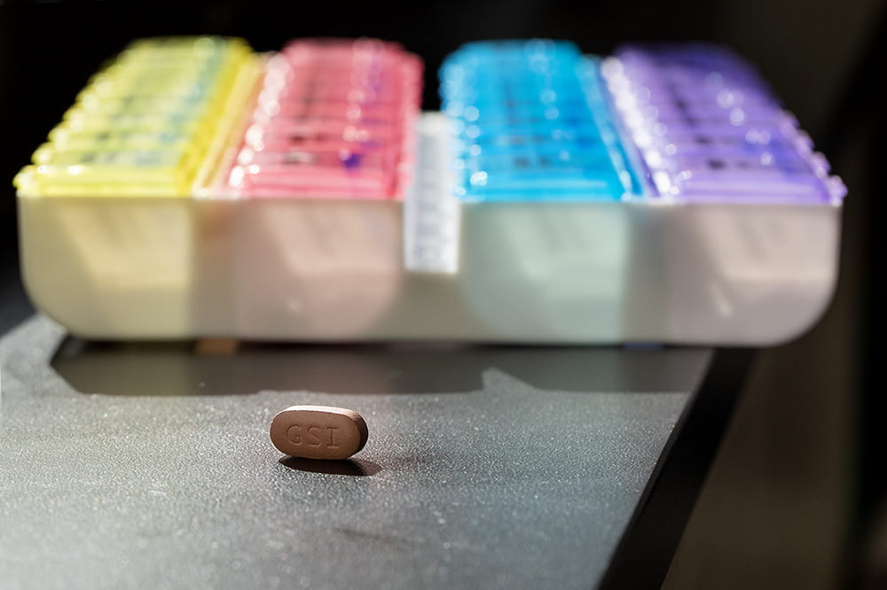 brown pill lying in front of a multicolored box