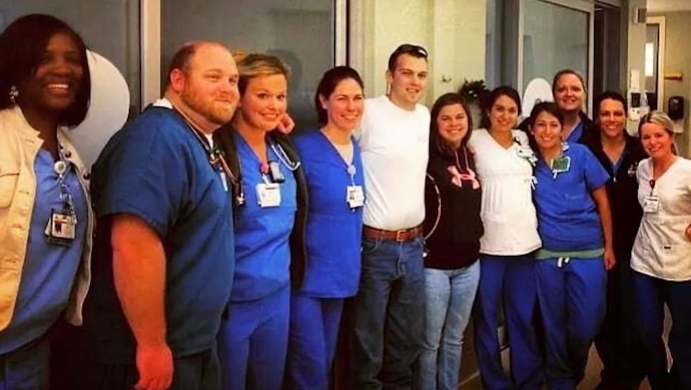 A large group of nurses surround Jordan