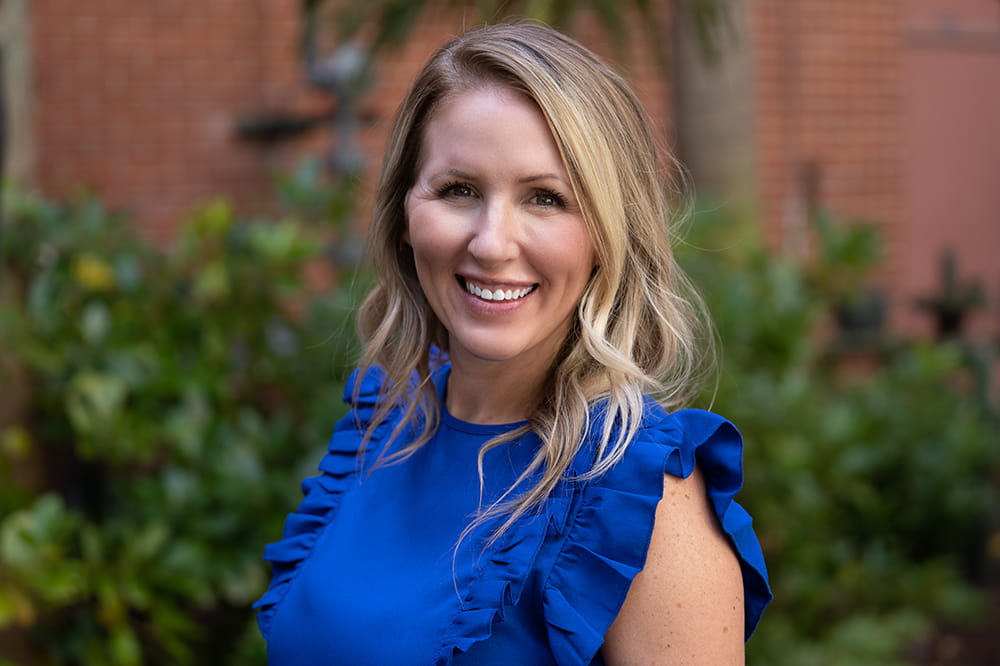 portrait of woman in a garden wearing blue for colorectal cancer awareness