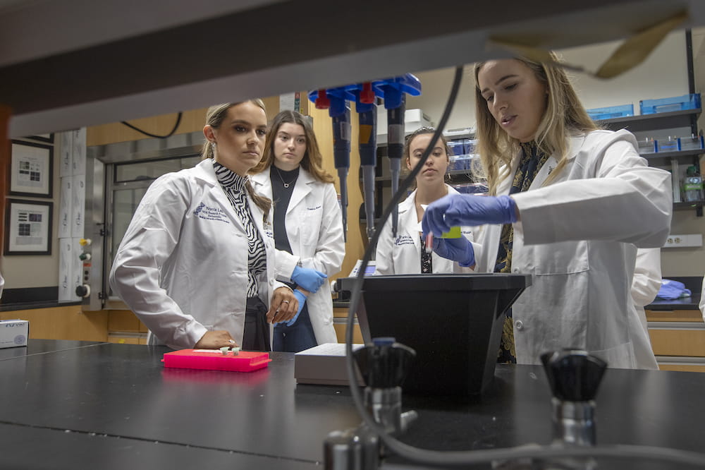 A group of four women using equipment in a research lab