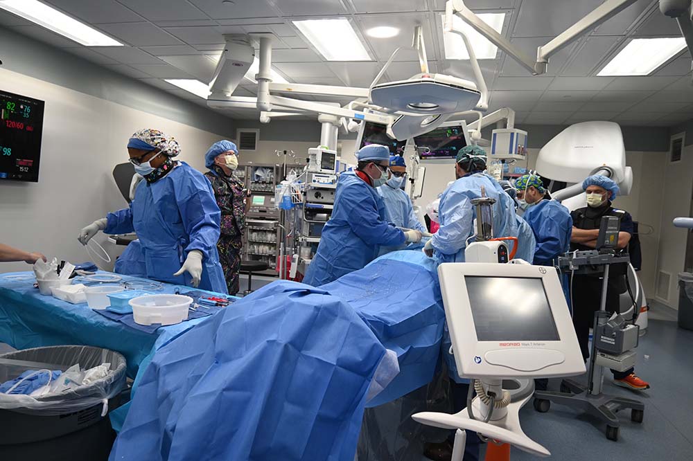 People wearing hospital scrubs work in an operating room.