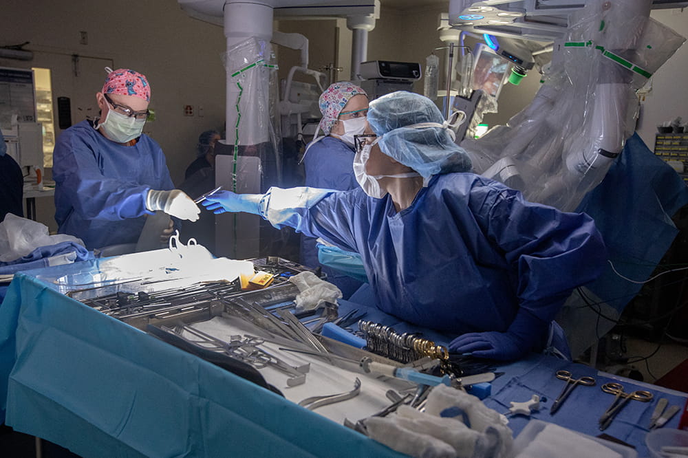 Jessica Waxman, a clinical practice nurse expert, right, hands an instrument to Cassie Johnson, CST in the OR during a kidney surgery. Photograph by Sarah Pack.