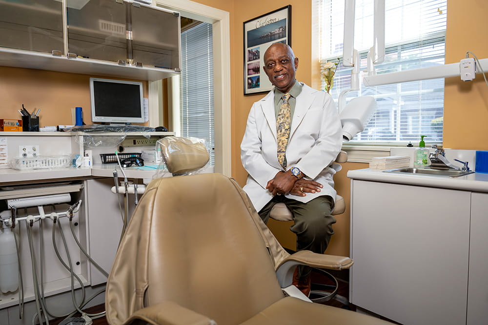 prostate cancer survivor Larry Ferguson poses in an exam room in his dental practice