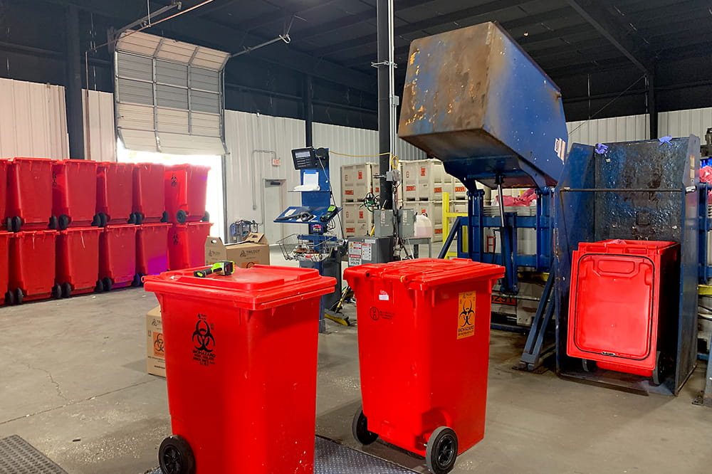 Red medical waste containers in what looks like a warehouse.