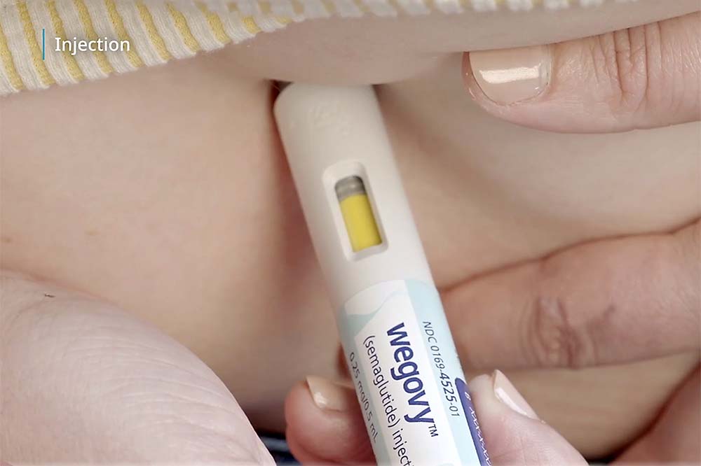 Closeup of a Wegovy pen going into skin.