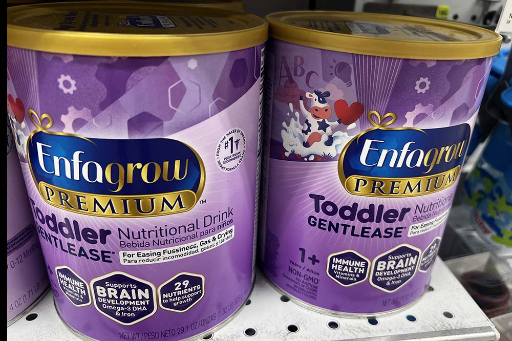 Two purple cans that say Enfagrow premium toddler nutritional drink,
