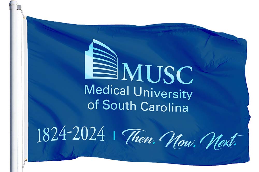 Blue flag with MUSC, Medical University of South Carolina, 1824-2024, Then, Now, Next written on it.