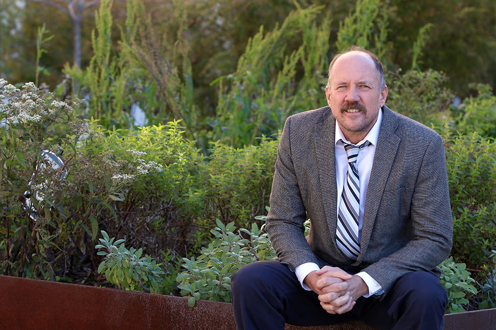 Mark Hamann sits in a garden