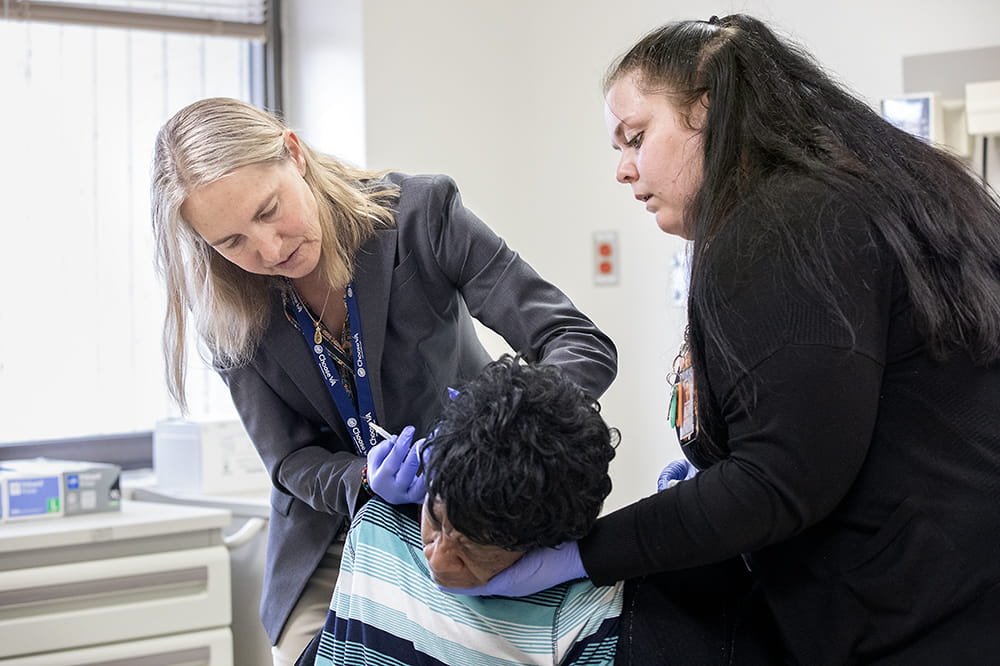 Dr. Hinson evaluating a Black patient with Parkinson's disease