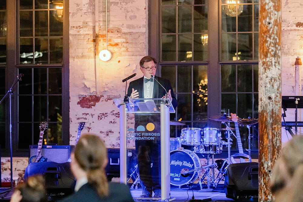 Dr. Flume at the podium of Cystic Fibrosis Foundation event where he was honored with the 2024  Impact Award, Photograph by Candice Adelle.
