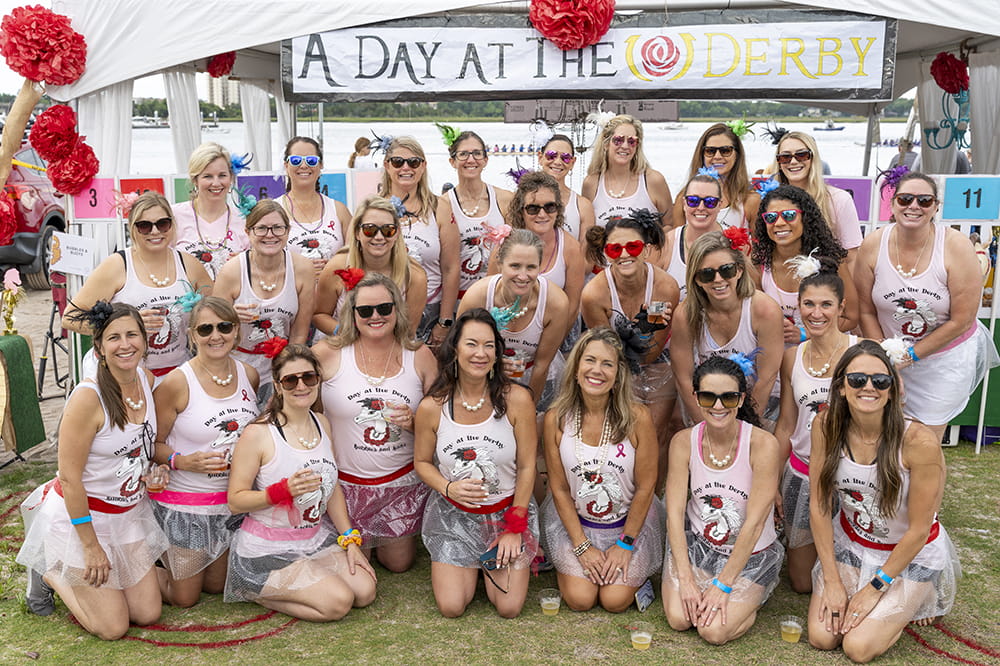 a group of women in faux ballerina skirts and tanks that say A Day at the Derby with an image of a girly horse pose for a photo