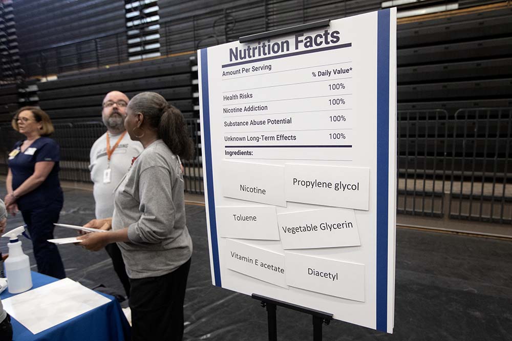 A large sign titled nutrition facts lists health risks, nicotine addiction, substance abuse potential and unknown long-term effects. It lists ingredients as nicotine, toluene, vitamin E acetate, propylene glycol, vegetable glycerin and diacetyl.