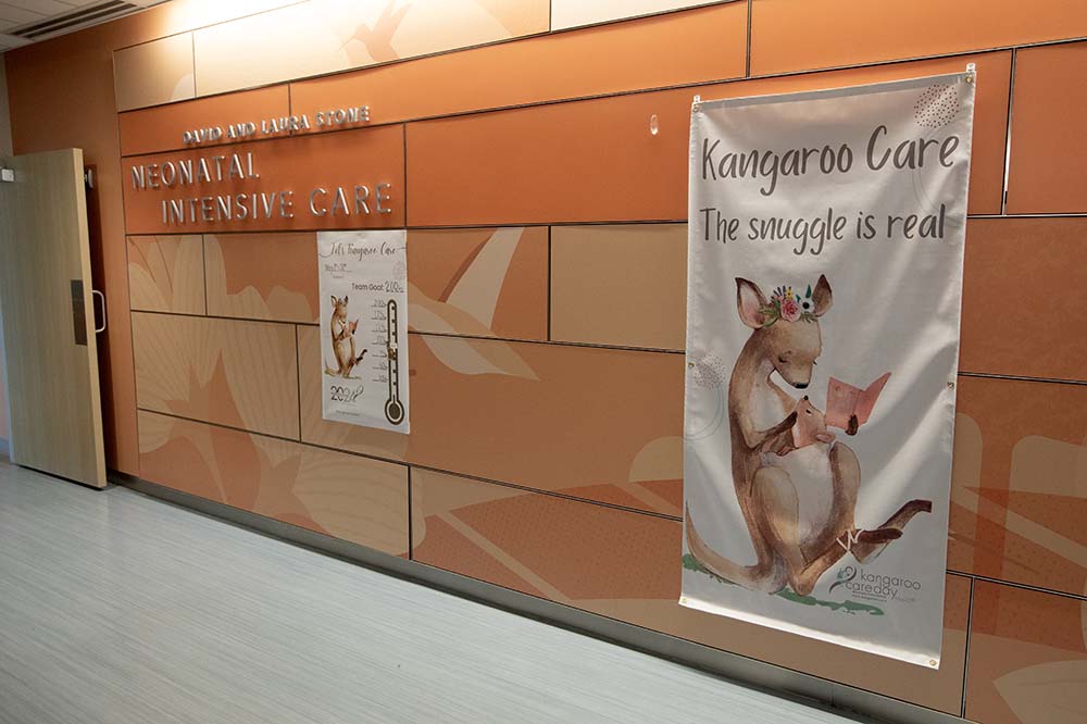 Banners that say kangaroo care: the snuggle is real hang in a hallway.