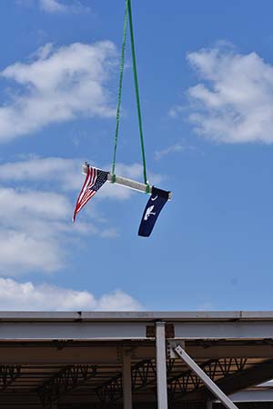 A beam with an American flag and a South Carolina flag hangs in the sky.