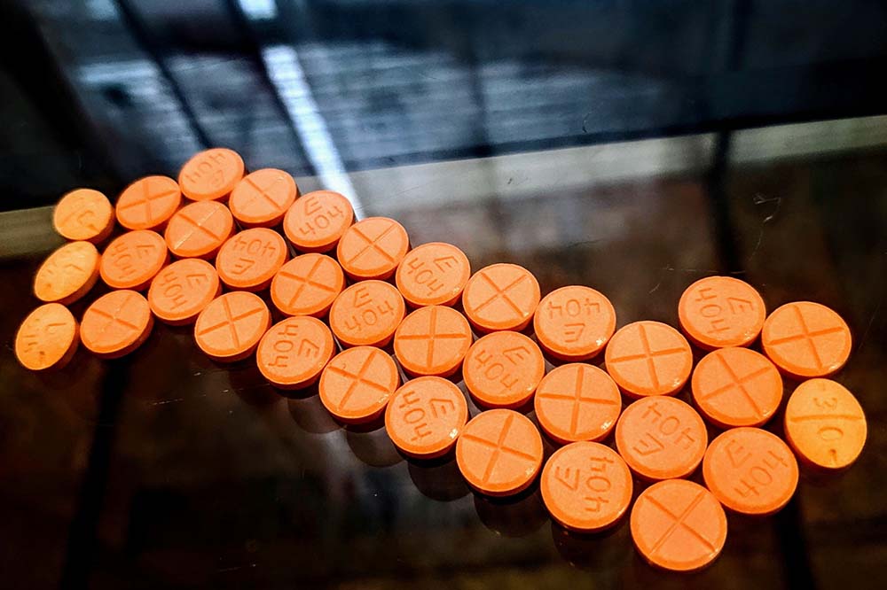 Rows of orange pills on a dark background.