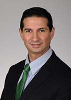 Headshot of a man in a coat and tie.