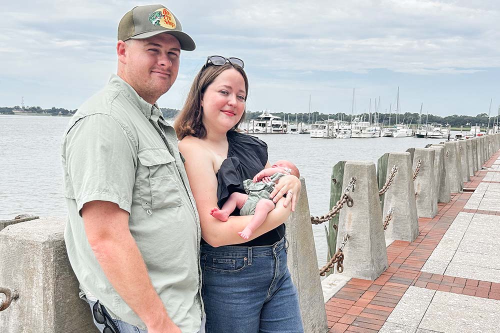 Man woman and baby on dock.